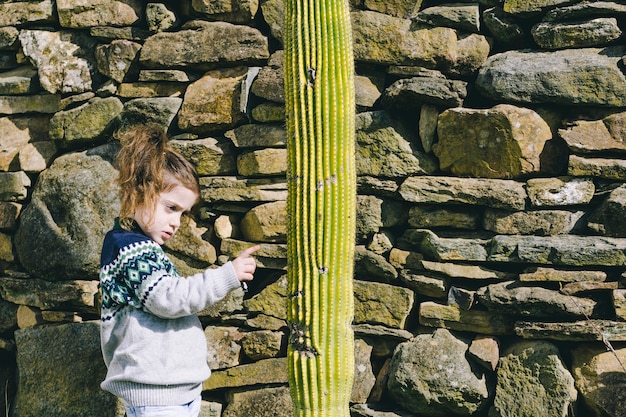 Chica tocando cactus