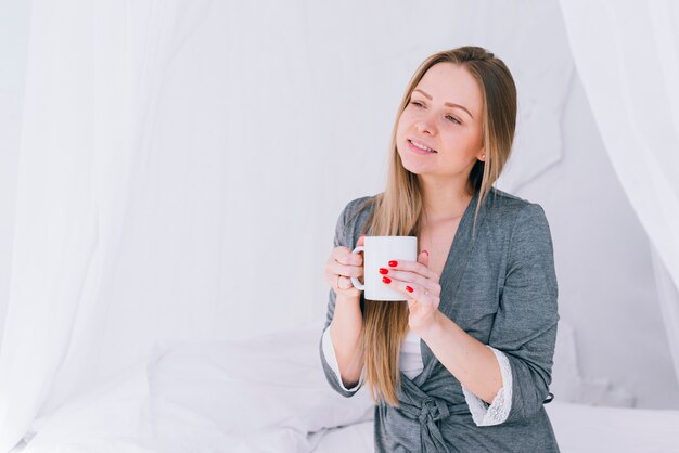 Chica tomando café en la cama