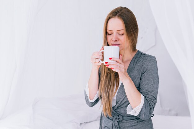 Chica tomando café en la cama