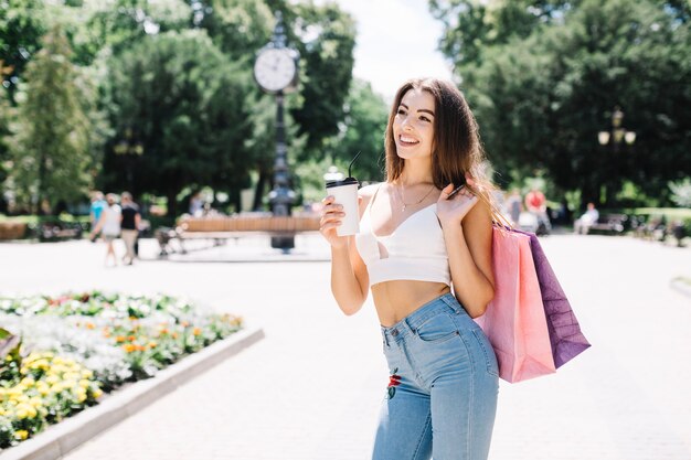 Chica tomando café después de ir de compras