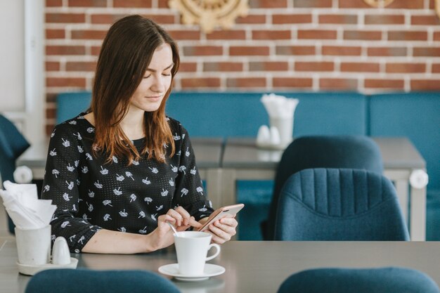 Chica tomando café en un restaurante