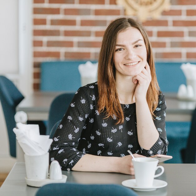 Chica tomando café en un restaurante