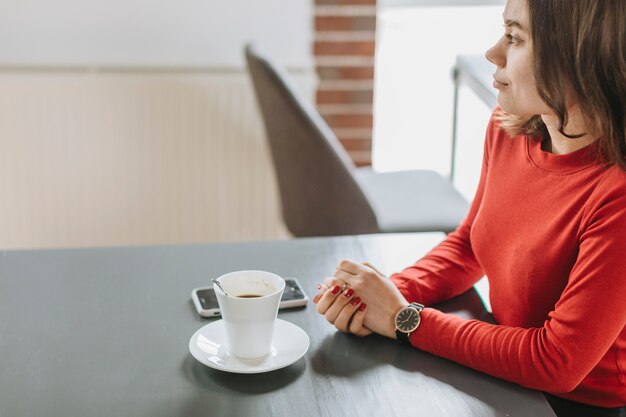 Chica tomando café en un restaurante