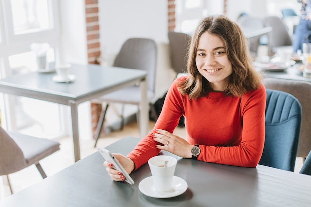 Chica tomando café en un restaurante