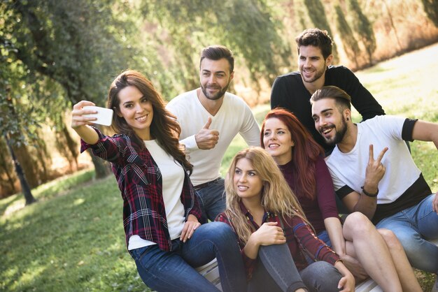 Chica tomando una foto con sus amigos en el parque