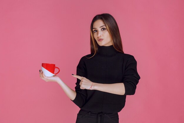 Chica tomando una taza de café en la pausa para el café.