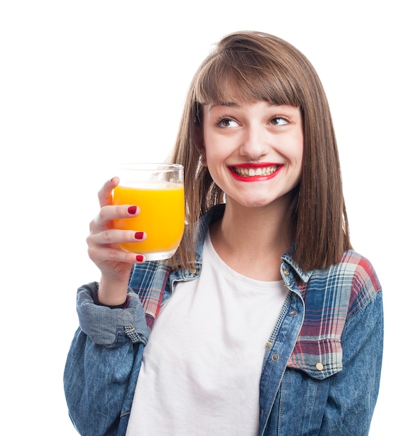 Chica tomando zumo de naranja para desayunar