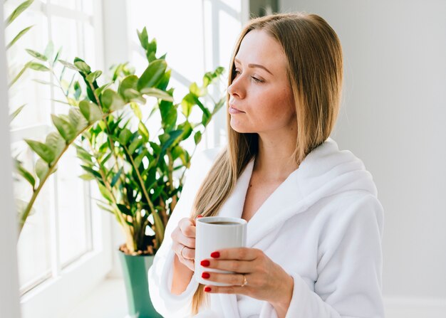 Chica tomándose un café en el baño