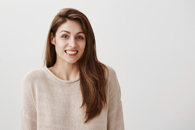 Chica tonta incómoda disculpándose y sonriendo culpable