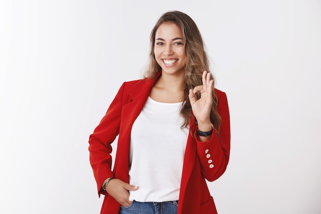 Chica totalmente confiada aseguró el trato ya en sus manos, mostrando un gesto bien ok sonriendo afortunado seguro de sí mismo sosteniendo el bolsillo de la mano. Exitosa empresaria feliz todo bien