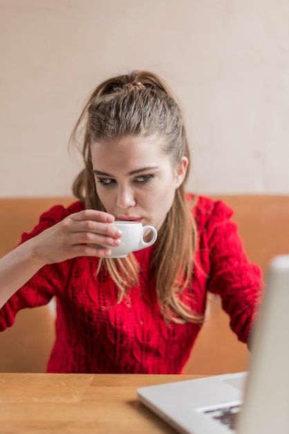 Foto gratuita chica trabajando y bebiendo un café