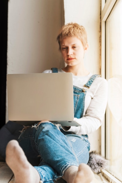 Chica trabajando con portátil gris