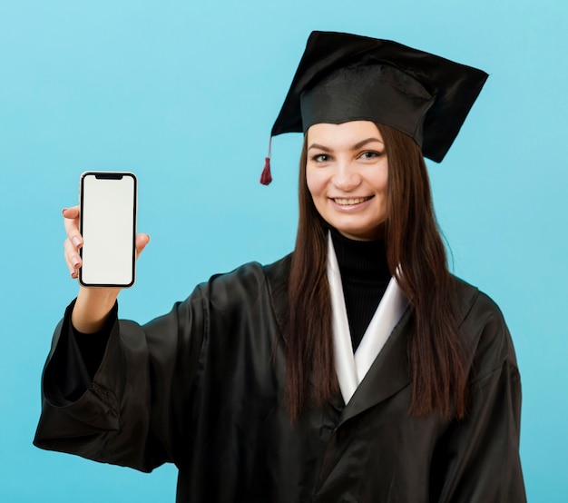 Chica en traje académico con teléfono