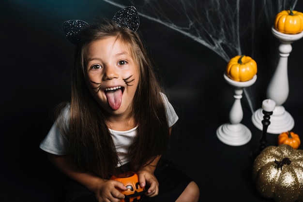 Chica en traje de gato mostrando la lengua