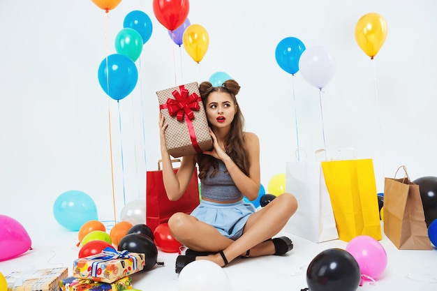 Chica en traje de moda averiguar qué hay en la caja