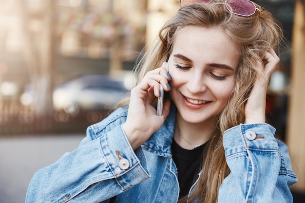 Chica tratando de excusarse a través de un teléfono inteligente hablando con un amigo y