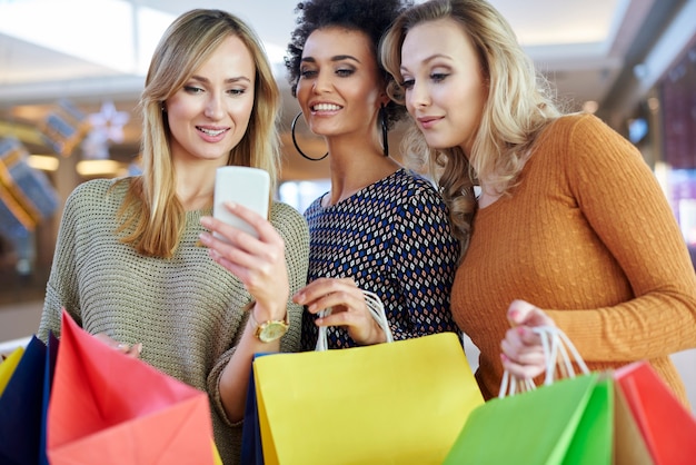 Chica usando su teléfono móvil durante las compras