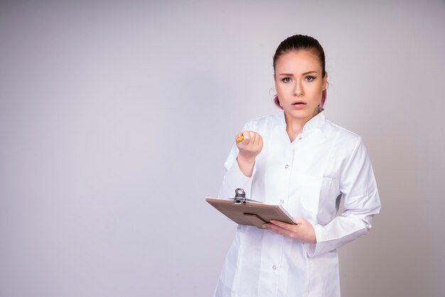 Chica vacilante en uniforme médico blanco