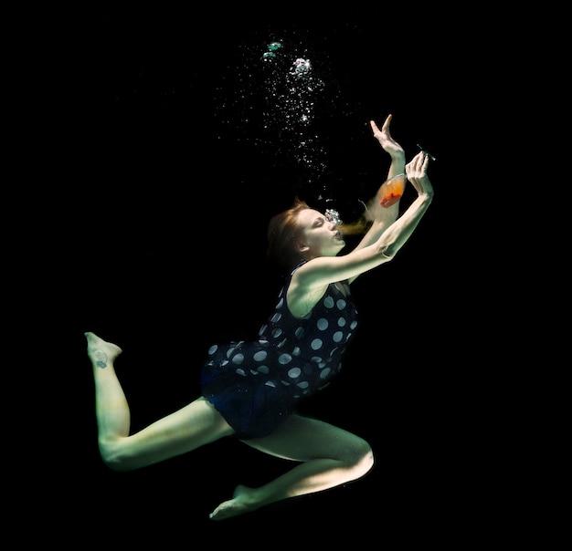 Chica con un vaso bajo el agua
