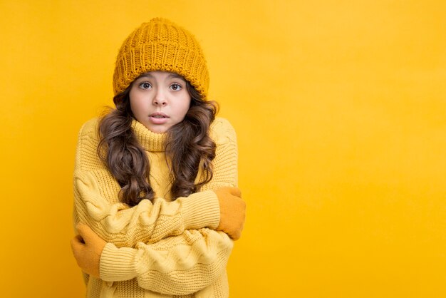 Chica vestida de amarillo con las manos cruzadas