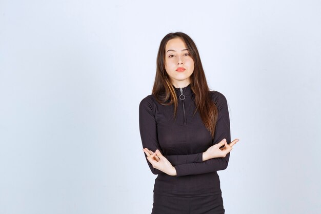 Chica vestida de negro haciendo meditación.