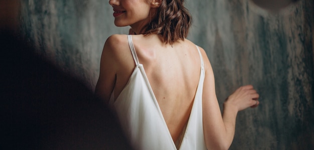 chica con un vestido blanco gira una cara con una sonrisa a un chico