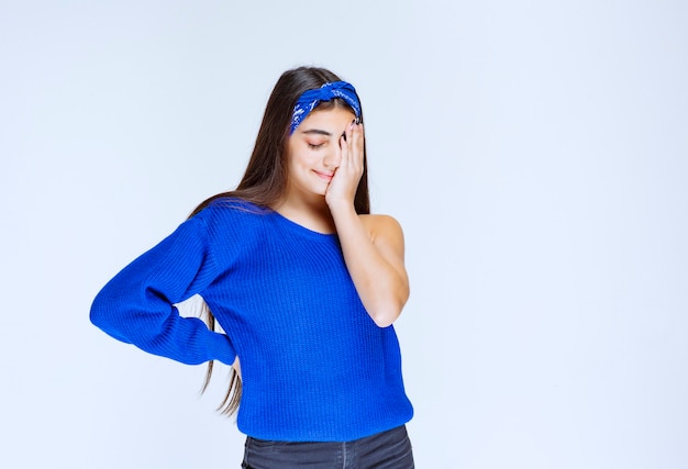 Chica en vestido de fiesta azul sosteniendo la cabeza mientras está confundida y sorprendida.