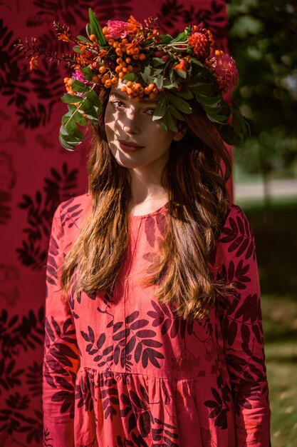 chica en un vestido de lino. Con una corona de flores en la cabeza.