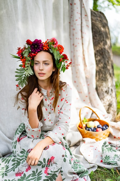 chica en un vestido de lino. Con una corona de flores en la cabeza.