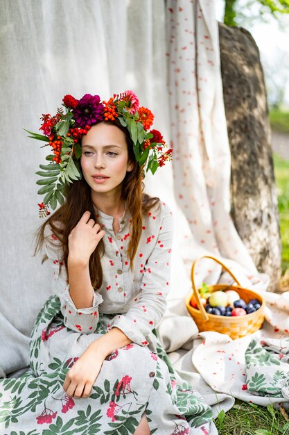 chica en un vestido de lino. Con una corona de flores en la cabeza.