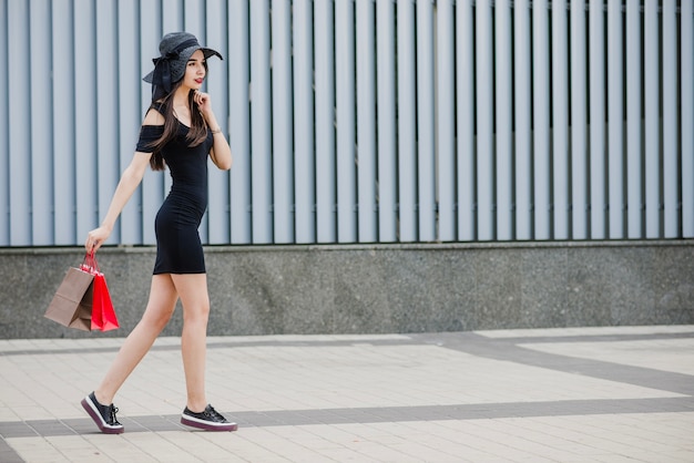 Chica en vestido negro caminando fuera