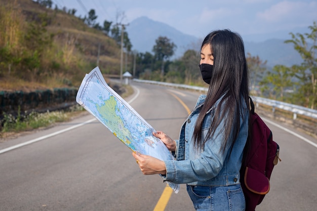 Chica viajera buscando la dirección correcta en el mapa