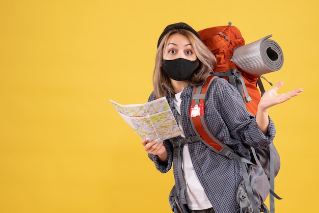 Foto gratuita chica viajera desconcertada con máscara negra y mochila con mapa