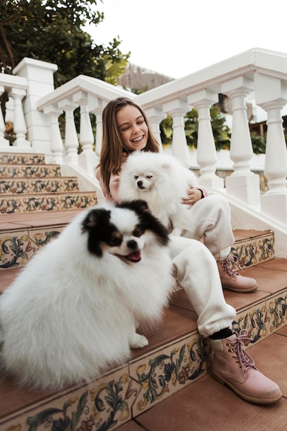 Chica de vista baja y sus perros en las escaleras