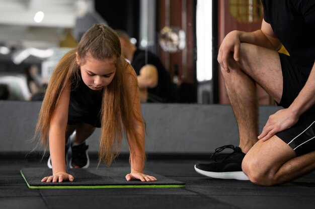 Chica de vista frontal entrenando en el gimnasio