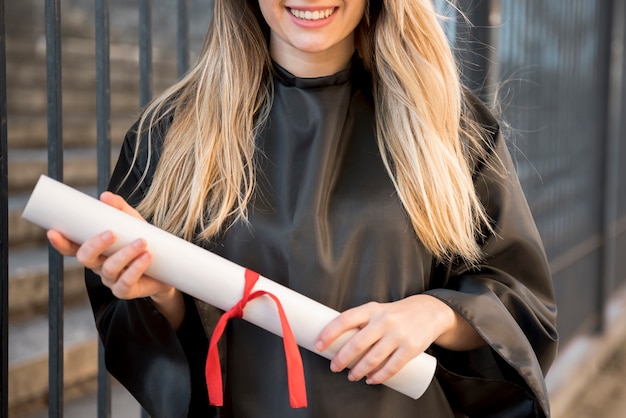 Foto gratuita chica vista frontal sonriendo sosteniendo su certificado