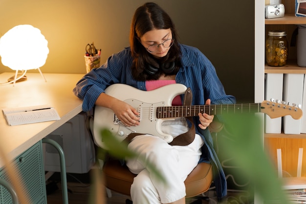 Chica de vista frontal tocando la guitarra