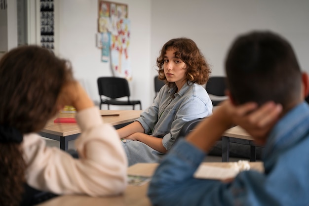 Chica de vista lateral siendo acosada en la escuela