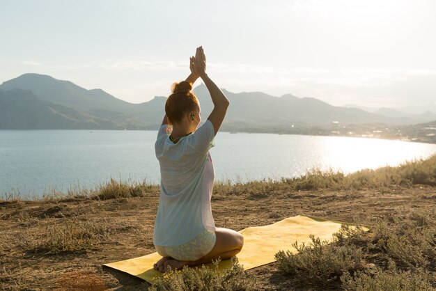 Chica de yoga con auriculares inalámbricos