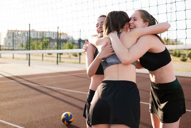 Foto gratuita chicas abrazándose en el campo de voleibol