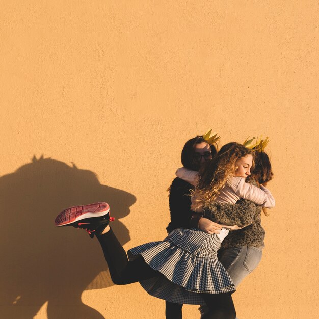 Chicas abrazándose cerca de la pared