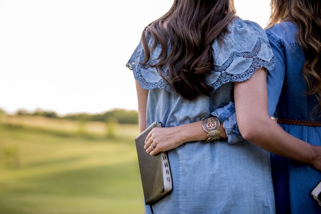 Chicas abrazándose mientras sostienen la Biblia