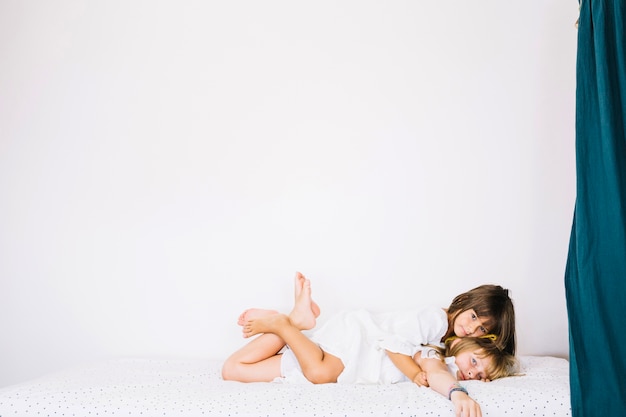 Chicas acostadas el uno al otro en la cama