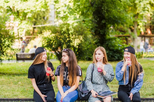 Chicas adolescentes bebiendo y charlando