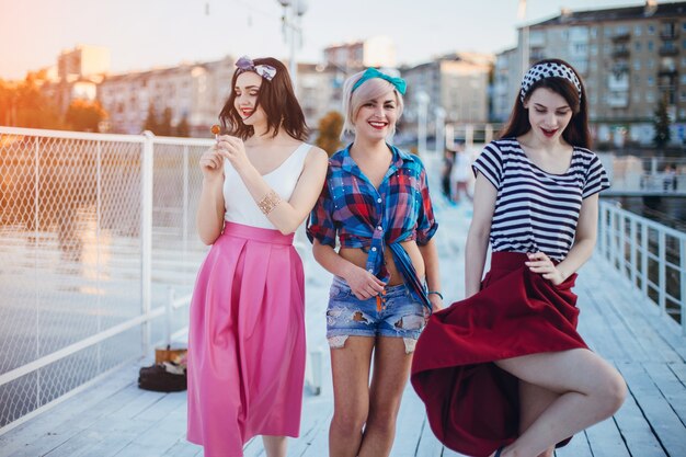 Chicas adolescentes sonriendo mientras pasean por un puerto