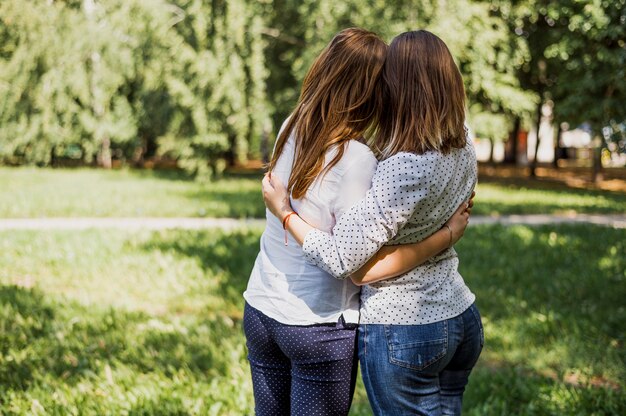 Las chicas adolescentes ven mientras se abrazan