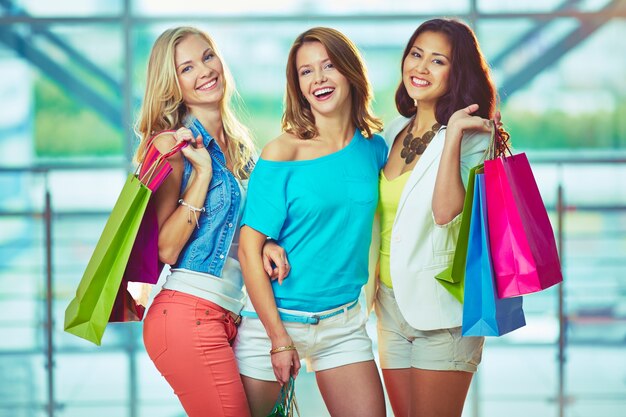 Chicas alegres con bolsas de la compra