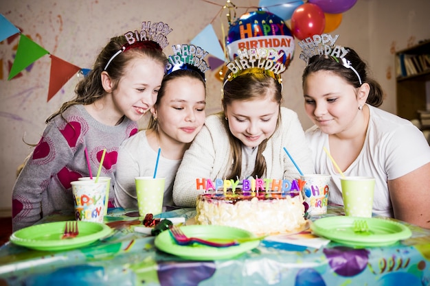 Chicas alegres mirando pastel