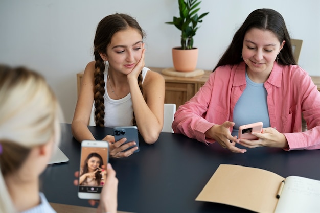 Chicas de alto ángulo con teléfonos inteligentes.