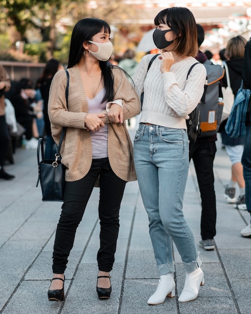 Chicas asiáticas bonitas con máscaras faciales